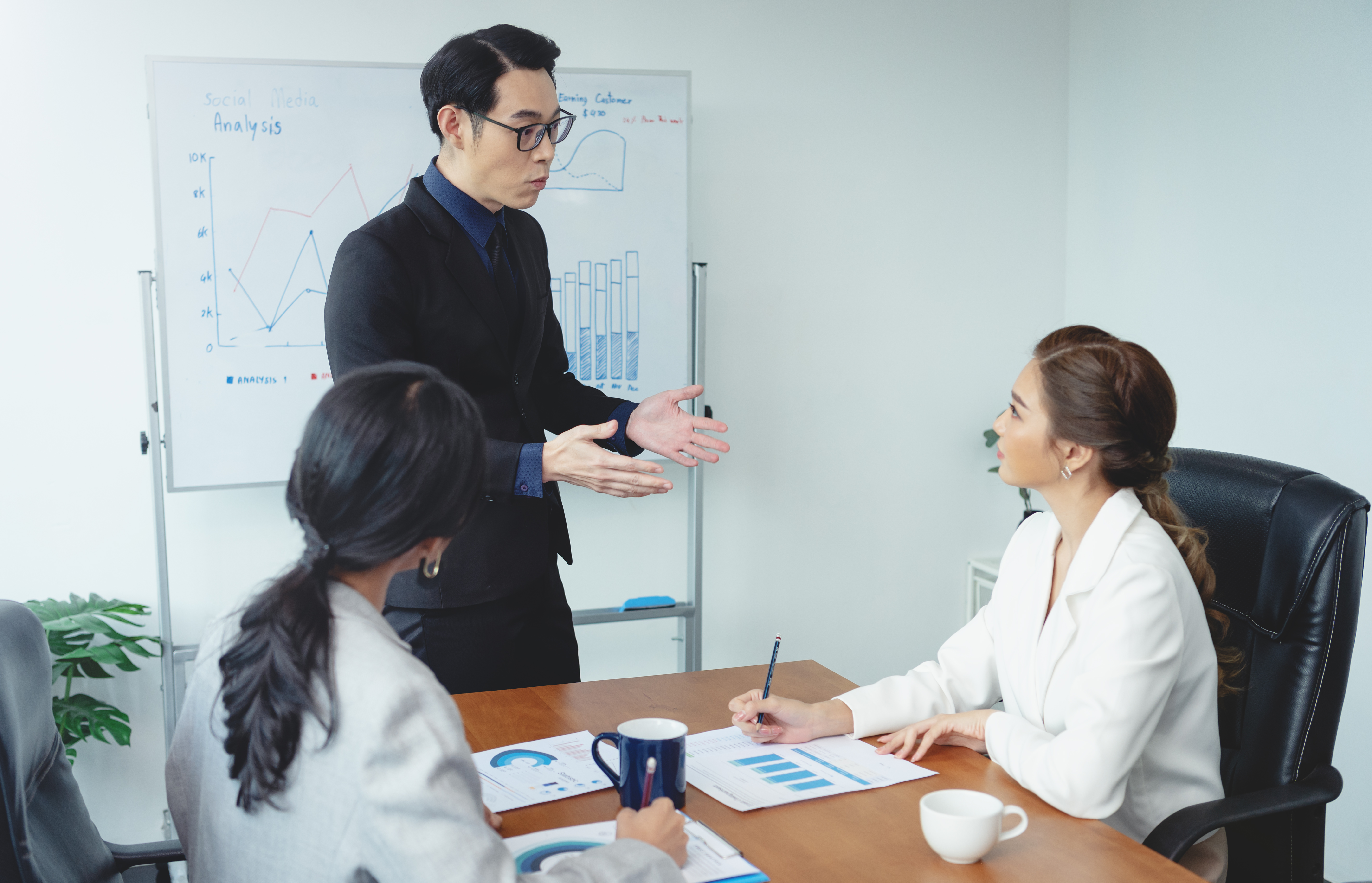 Asian businessman presenting of his work to corporate colleagues